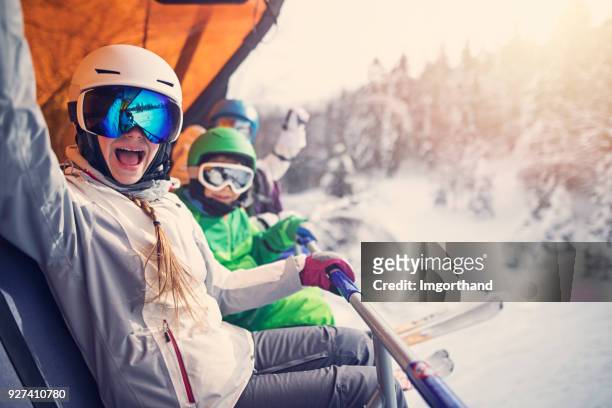 madre con los niños sentados en un telesilla - skiing fotografías e imágenes de stock