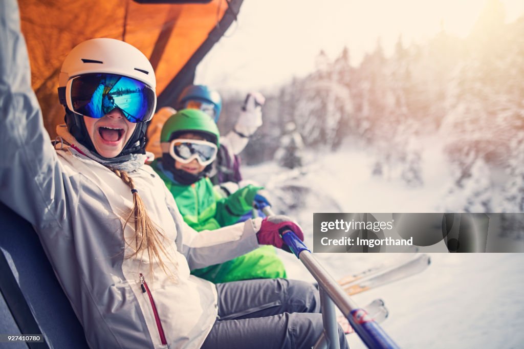 Mother with kids sitting on a ski lift