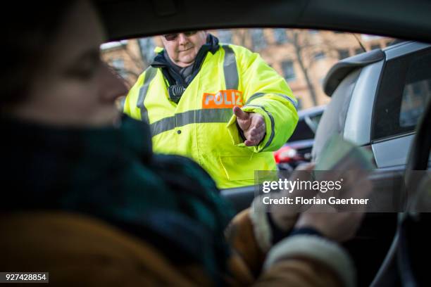 Set scene during a traffic control in Berlin. A young woman is stopped by the police and has to show her papers on February 27, 2018 in Berlin,...