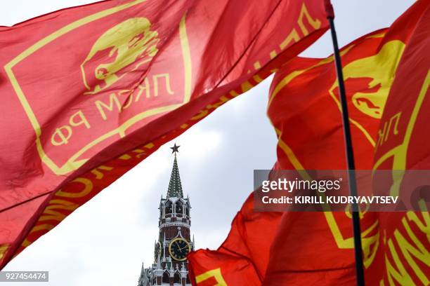 Red flags with an image of Vladimir Lenin flutter in the wind as Russian Communist party supporters attend a memorial ceremony to mark the 65th...