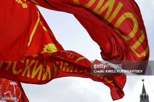 Red flags with an image of Vladimir Lenin flutter in the wind as Russian Communist party supporters attend a memorial ceremony to mark the 65th...