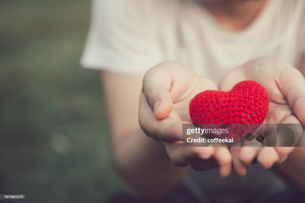 Compartir amor y corazón color rojo de la mujer de la mano en tono de color de la vendimia de San Valentín