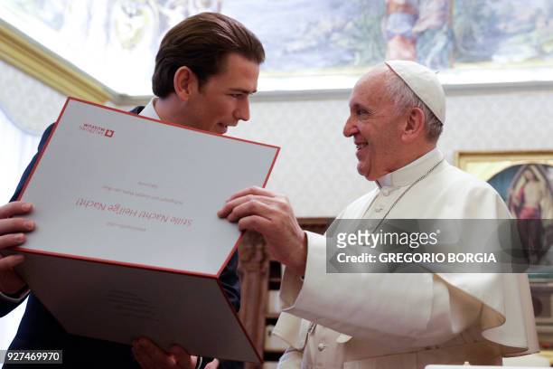 Pope Francis exchanges gifts with Austrian Chancellor Sebastian Kurz during a private audience at the Vatican on March 5, 2018. / AFP PHOTO / POOL /...