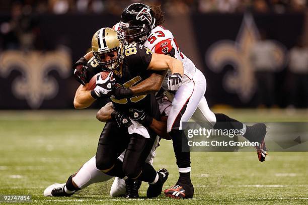 David Thomas of the New Orleans Saints runs for a first down against Erik Coleman and Mike Peterson of the Atlanta Falcons during the first quarter...