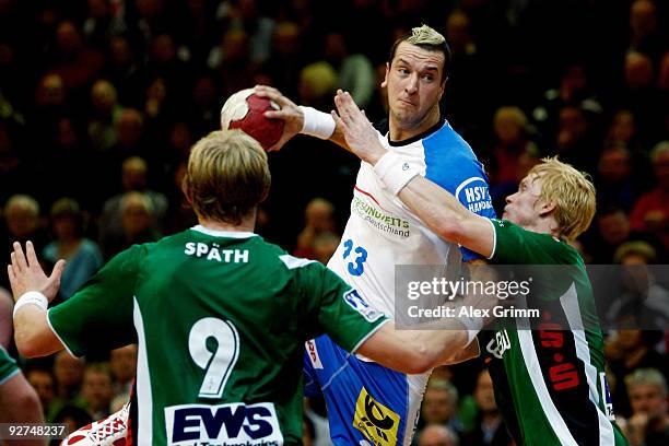 Pascal Hens of Hamburg is challenged by Manuel Spaeth and Christian Schoene of Goeppingen during the Toyota Handball Bundesliga match between FA...