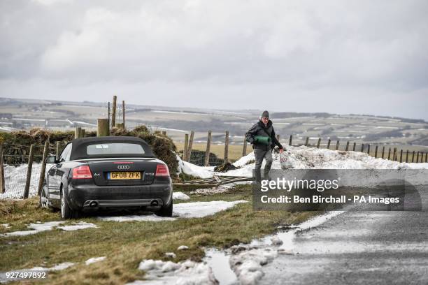Man returns to his car he abandoned on the A39, Exmoor, near Lynton, due to the recent severe weather, as the road remains closed due to snow.