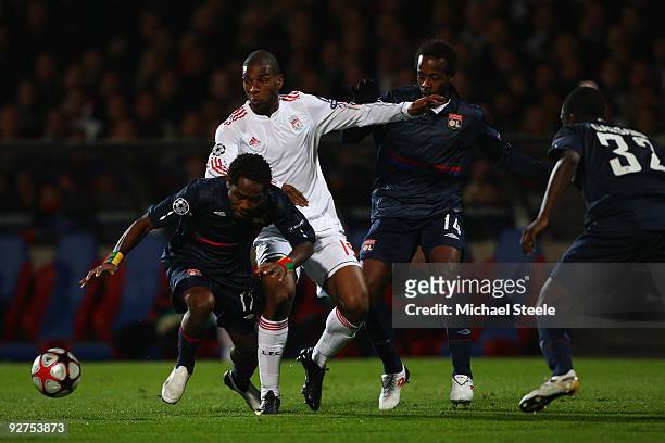 Ryan Babel of Liverpool challenged by Jean II Makoun and Sidney Govou during the UEFA Champions League Group E match between Lyon and Liverpool at...