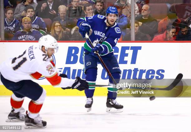 Sven Baertschi of the Vancouver Canucks passes the puck up ice past Vincent Trocheck of the Florida Panthers during their NHL game at Rogers Arena...