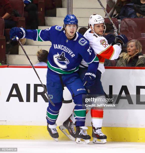 Ben Hutton of the Vancouver Canucks checks Micheal Haley of the Florida Panthers during their NHL game at Rogers Arena February 14, 2018 in...