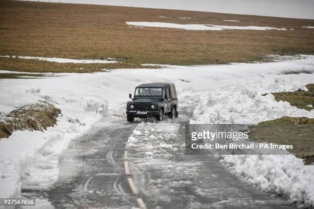 4x4 vehicle travels along a recently cleared section of the A39 at Porlock Hill, near Lynton, Exmoor, after heavy snow drifts affected the area and...