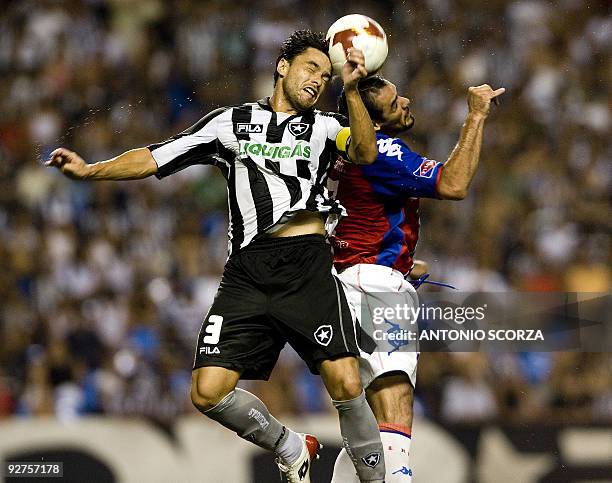 Botafogo defender Juninho heads the ball with Celso Ortiz of Cerro Porteno during their Sudamerica Cup semifinal football match at Engenhao stadium...
