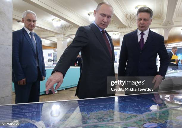 Russian President Vladimir Putin , Transport Minister Maksim Sokolov and Presidential Aide Andrei Belousov observe a model of new highway to Crimea...