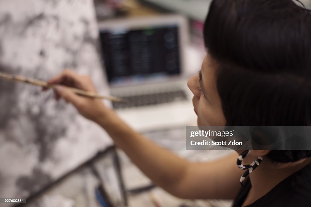 Artist painting in her studio