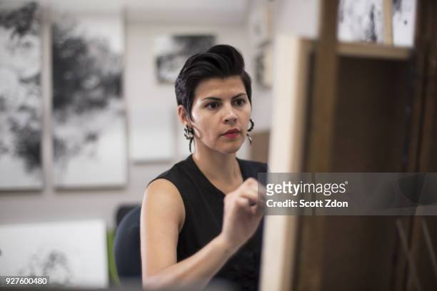 hispanic artist working in her studio - scott zdon foto e immagini stock
