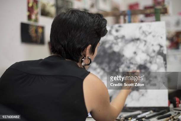 hispanic artist working in her studio - scott zdon stock-fotos und bilder