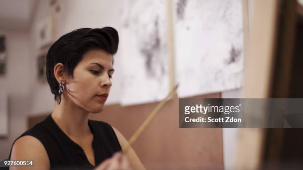 artist painting in her studio - scott zdon foto e immagini stock
