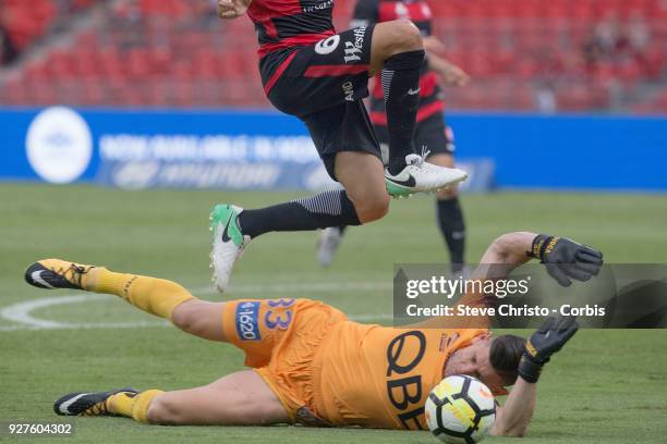 Glory's Liam Reddy slides under Marcelo Carrusca of the Wanderers during the round 23 A-League match between the Western Sydney Wanderers and Perth...