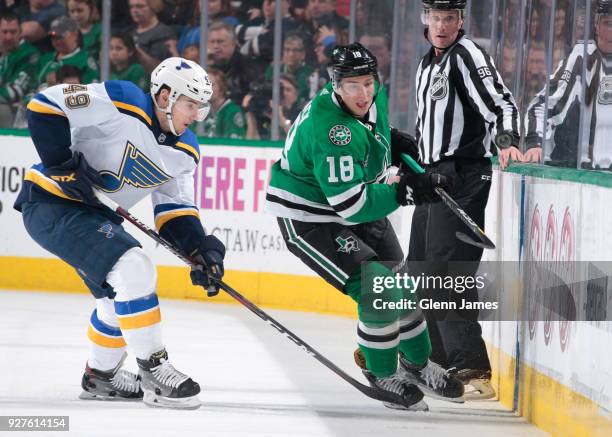 Tyler Pitlick of the Dallas Stars tries to keep the puck away against Ivan Barbashev of the St. Louis Blues at the American Airlines Center on March...