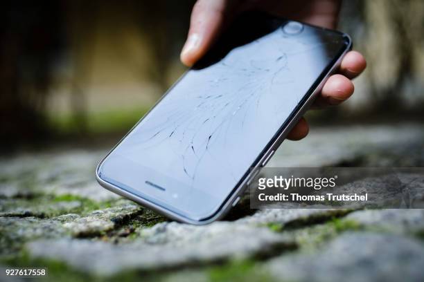 Berlin, Germany An Apple Iphone with shattered glass is picked up from the ground on March 05, 2018 in Berlin, Germany.