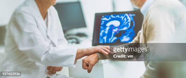 doctor consoling patient with brain tumour - tomografia por emissão de positrões imagens e fotografias de stock