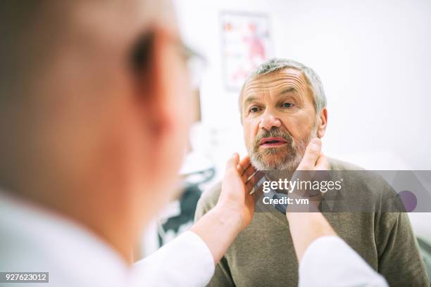 doctor examining patient's throat - throat exam stock pictures, royalty-free photos & images