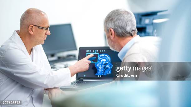 médecin patient montrant son brainscan - display cabinet photos et images de collection