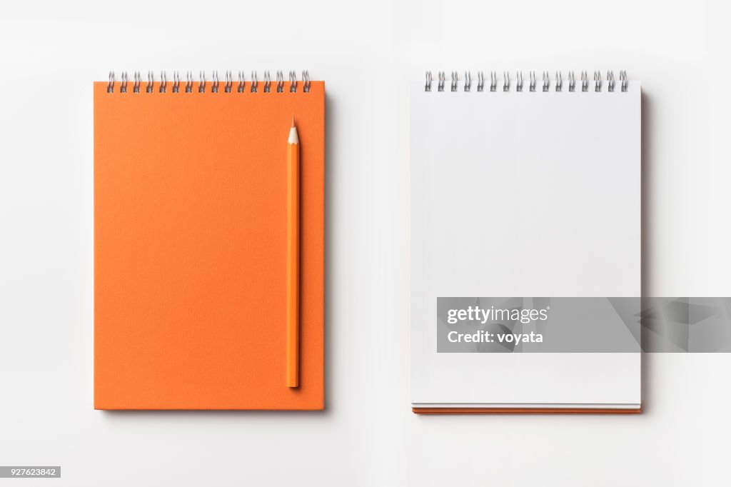 Top view of orange spiral notebook and color pencil collection