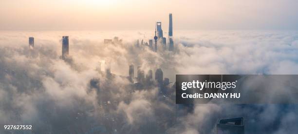 panoramic view of shanghai city over the advection fog at sunrise - china pollution stock-fotos und bilder