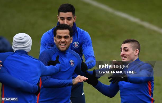 Paris Saint-Germain's Italian midfielder Marco Verratti jokes with Paris Saint-Germain's Brazilian defender Dani Alves during a training session at...
