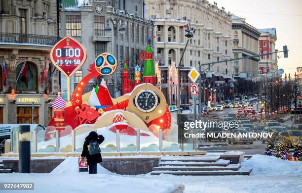 Woman looks at the digital FIFA World Cup 2018 countdown clock placed in front of the Red Square and the Kremlin in Moscow marking 100 days to the...