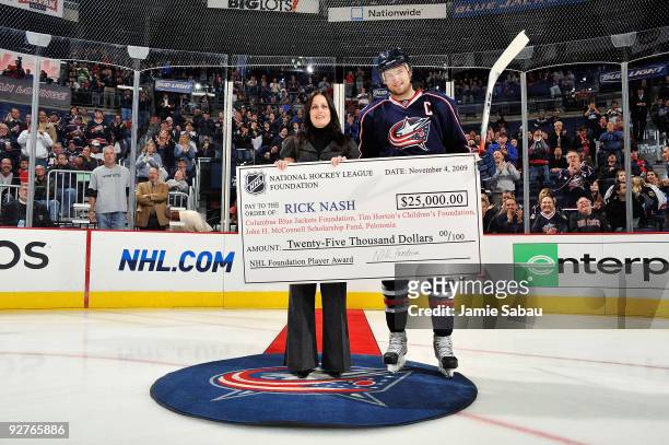 Rick Nash of the Columbus Blue Jackets, winner of the NHL Foundation Award, is presented with a check for $25,000 to donate to the charity of his...