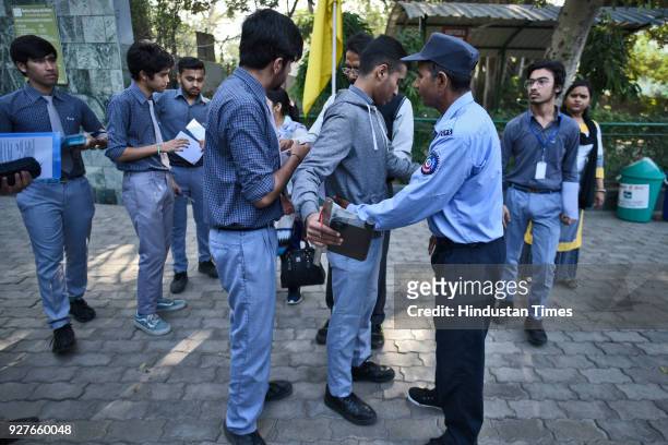 Security guard checks a student before the start of class X and XII CBSE board exams, outside examination centre, at Kendra Vidyala Gole Market, on...
