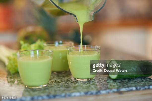 pouring a freshly made organic smoothie, close up. - cucumber stockfoto's en -beelden