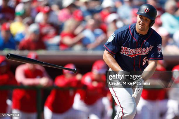 Chris Heisey of the Minnesota Twins throws his bat after drawing a walk during the second inning of the spring training game against the Philadelphia...