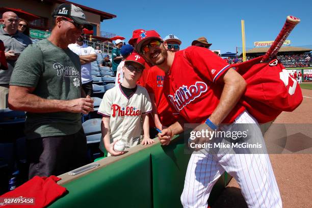 Adam Rosales of the Philadelphia Phillies poses for a picture with a fan before the spring training game against the Minnesota Twins at Spectrum...