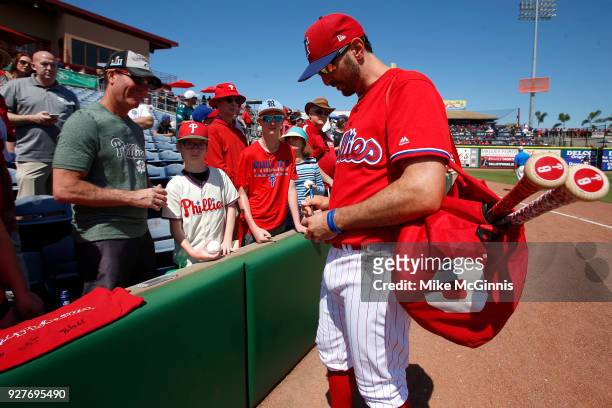 Adam Rosales of the Philadelphia Phillies signs some autographes before the spring training game against the Minnesota Twins at Spectrum Field on...