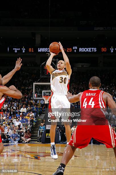 Stephen Curry of the Golden State Warriors shoots a jump shot against Chuck Hayes of the Houston Rockets during the game at Oracle Arena on October...