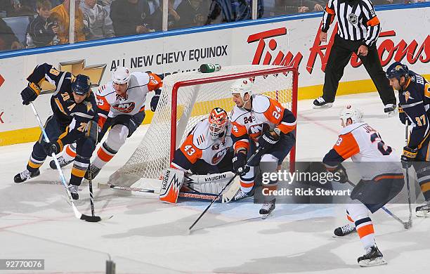 Paul Gaustad of the Buffalo Sabres turns toward the net as Andy Sutton, Martin Biron, Radek Martinek and Tim Jackman of the New York Islanders defend...