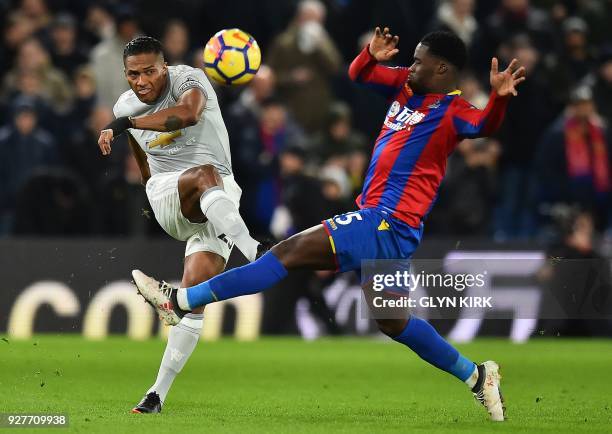 Manchester United's Ecuadorian midfielder Antonio Valencia vies with Crystal Palace's German midfielder Jeffrey Schlupp during the English Premier...