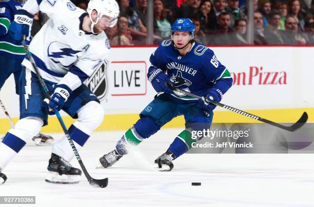 Markus Granlund of the Vancouver Canucks looks on as Victor Hedman of the Tampa Bay Lightning skates up ice with the puck during their NHL game at...
