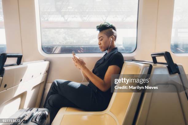 jeune femme d’affaires hanche à l’aide de téléphone portable dans le train - coiffure punk photos et images de collection