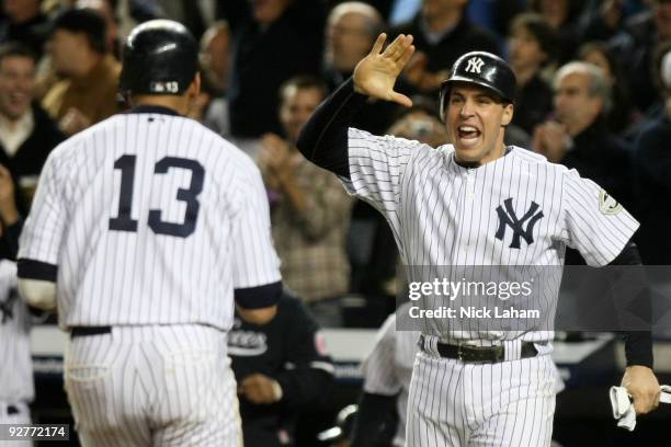 Mark Teixeira and Alex Rodriguez of the New York Yankees celebrate after they scored on a 2-run double in the bottom of the fifht inning against the...