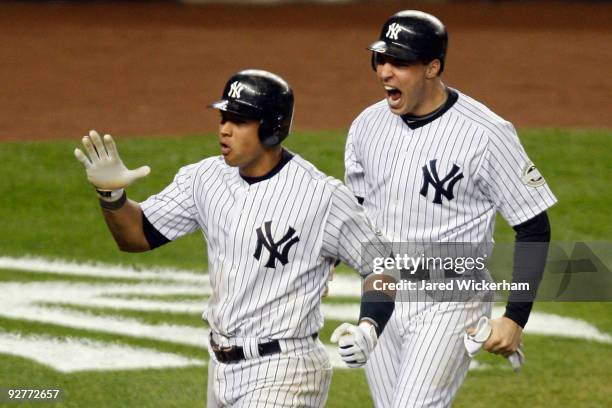 Mark Teixeira and Alex Rodriguez of the New York Yankees celebrate after they scored on a 2-run double by Hideki Matsui in the bottom of the fifth...