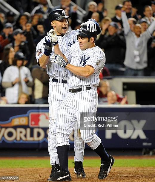 Derek Jeter and Johnny Damon of the New York Yankees celebrate after scoring in the bottom of the third inning of Game Six of the 2009 MLB World...