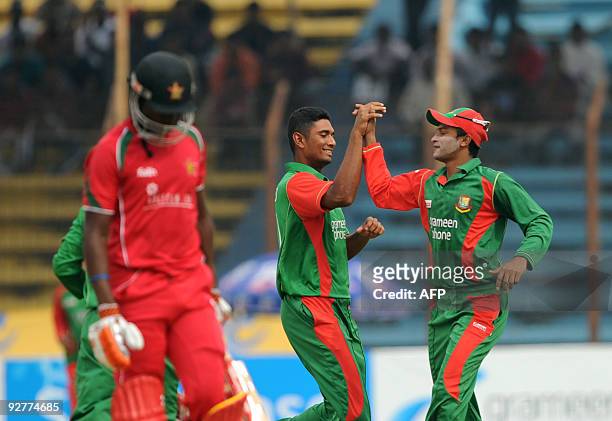 Bangladesh's team captain Shakib Al Hasan celebrates with his teammate Mahmud Ullah after the dismissal of Zimbabwe's Elton Chigumbura during the...