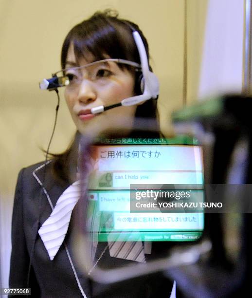 An employee for Japanese computer giant NEC displays the automatic translation system "Tele Scouter", used with a head mount display , at the...