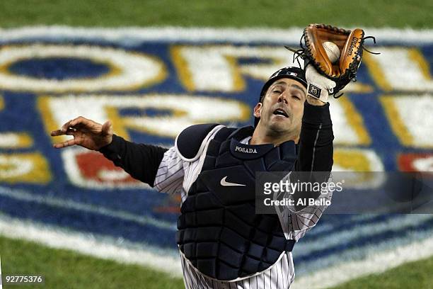 Jorge Posada of the New York Yankees catches a pop fly for the third out in the top of the eighth inning against Pedro Feliz of the Philadelphia...