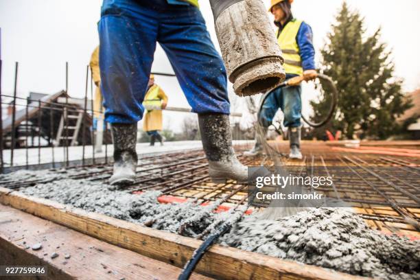 bouwvakkers gieten cement op dak - goot stockfoto's en -beelden