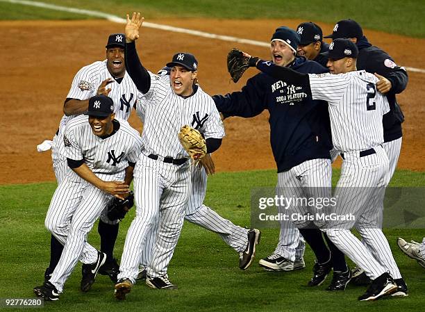 Mariano Rivera , Mark Teixeira and Derek Jeter of the New York Yankees celebrate with teammates after their 7-3 win against the Philadelphia Phillies...
