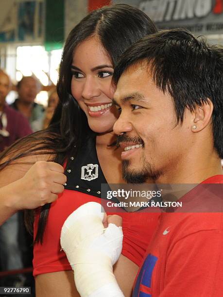 Welterweight boxing champion Manny "PacMan" Pacquiao of the Philippines, poses with a model as he prepares for his fight against Miguel Cotto, at the...